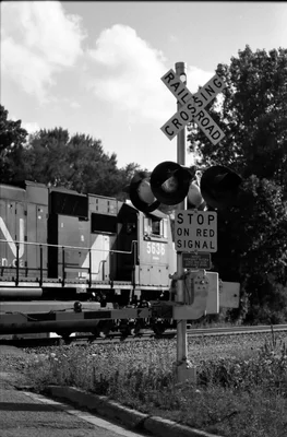train passing railroad crossing with warning signals
