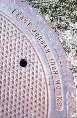 weathered manhole cover with embossed text on ground