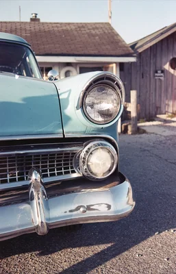 vintage turquoise car front detail sunlit driveway