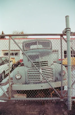 old truck behind chain link fence