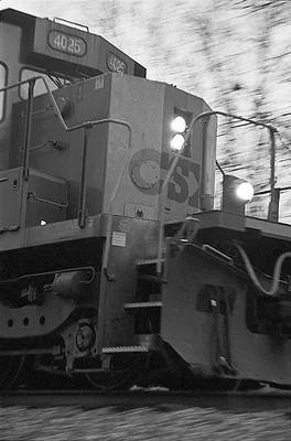 locomotive engine in motion with headlights illuminated