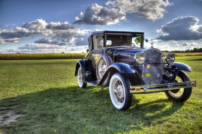 vintage blue car on grass field