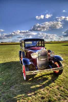 vintage burgundy car on grass field