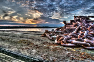 rusty chains on weathered dock at sunset